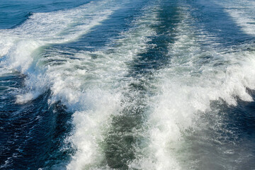 Wake of a ferry boat in the blue ocean. Abstract travel and tourism concept