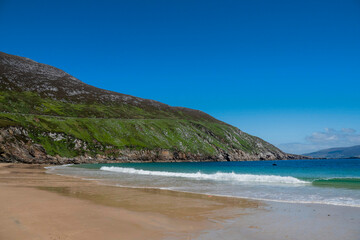 Fototapeta na wymiar Beautiful sandy Keem beach in Achill island, county Mayo, Ireland. Warm sunny day. Popular travel area with amazing view and nature.