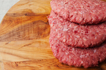 Stack of fresh burgers on a wooden board. Meat industry product. Simple food. Copy space