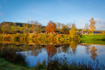 Fototapeta premium Reflection of nature and bright autumn colors in the lake Wirft, Stadtkyll, Germany