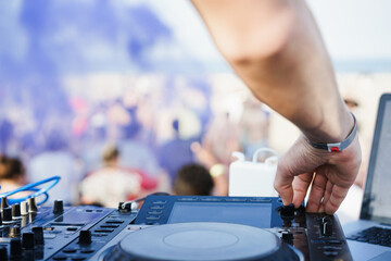 Dj mixing at beach party during summer vacation outdoor - Focus on right hand