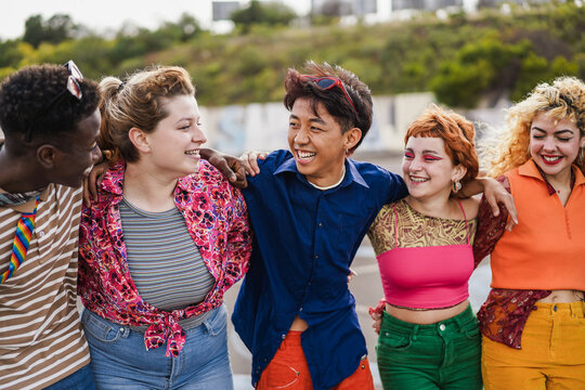 Young diverse friends having fun outdoor laughing together - Main focus on asian guy face