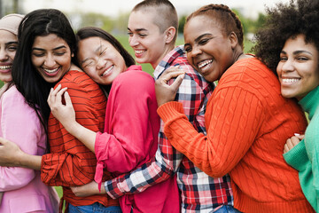 Multiracial female friends having fun hugging together outdoor - Focus on african girl face