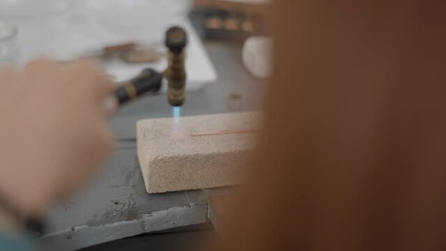 Professional Jeweler Using Blow Torch Melting A Piece Of Metal. Selective Focus Shot