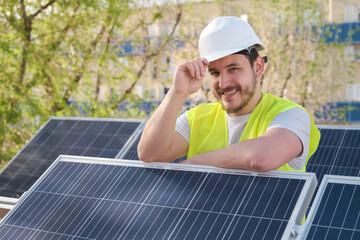 Portrait of a solar panels technician looking at camera after installing photovoltaic solar station.