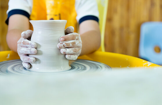 Young boy making a pitcher of clay