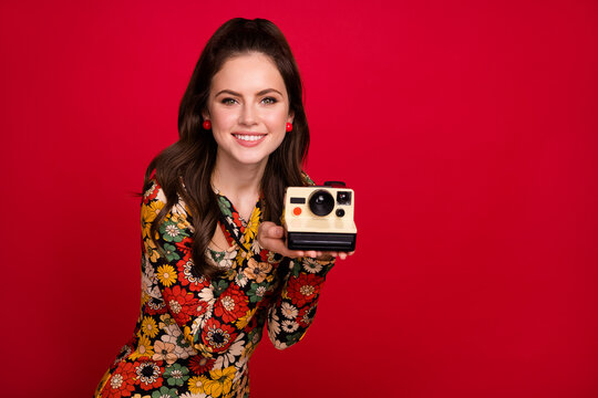 Portrait of attractive cheerful girl holding old fashioned cam making capture cadre isolated over bright red color background