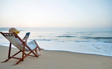 Young woman holding digital tablet at the beach.