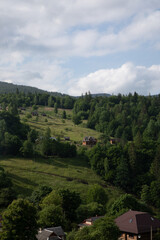 Fototapeta premium Mountain summer landscape, houses on mountain green hills and blue sky