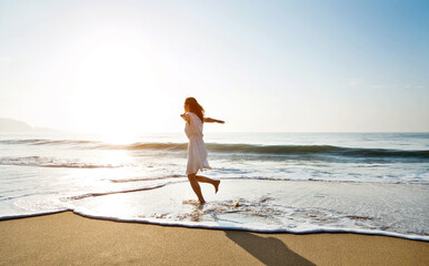 Young woman having fun walking on seaside.