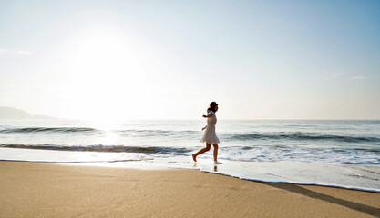 Fototapeta na wymiar Young woman having fun walking on seaside.