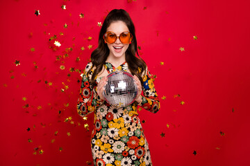 Portrait of attractive cheerful girly girl holding silver disco ball having fun isolated over...