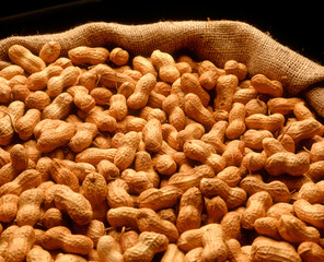 peanuts on rustic bag on white background.