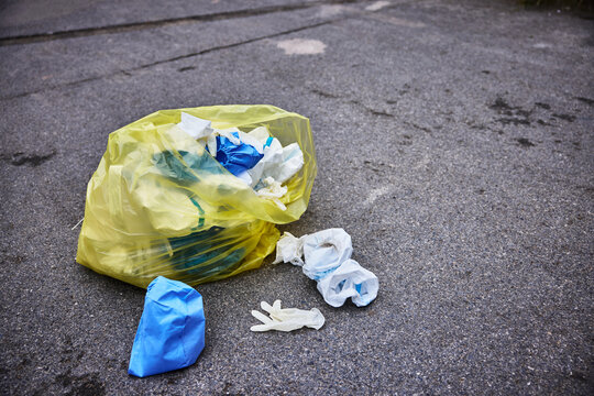 Yellow trash bag of biohazard medical waste on the street, environmental pollution due to the flu pandemic.