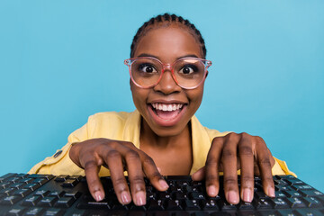 Portrait of attractive amazed cheerful girl writing text on keyboard having fun isolated over...