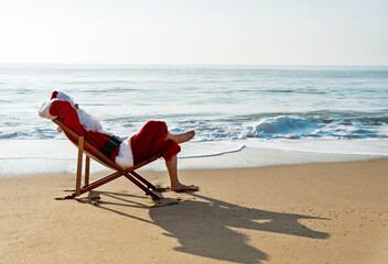 Christmas santa claus lying on a beach chair.