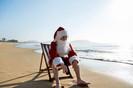 Christmas Santa Claus Lying On A Beach Chair.