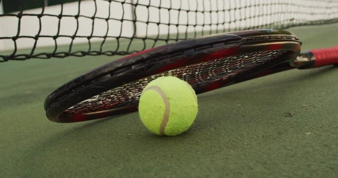 Video of tennis racket and ball lying on tennis court