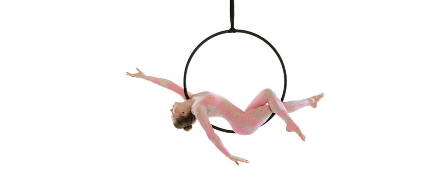 Portrait of young sportive girl, air gymnast performing on hoop isolated over white studio background. Flyer image