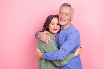 Portrait of two handsome beautiful sweet kind affectionate people cuddling isolated over pink pastel color background