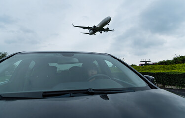 Fototapeta na wymiar An airplane flying over the car