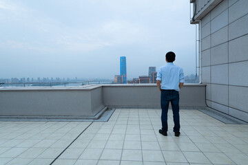 Businessman standing on the rooftop with hands in pocket