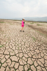 woman walking in dryland with drought ground texture. concept climate changed.