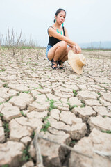 woman walking in dryland with drought ground texture. concept climate changed.