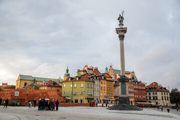 Fototapeta na wymiar Warsaw, Poland, 13 October 2021: picturesque street with colorful buildings in historic center in medieval city, renaissance and baroque historical buildings at castle square, Sigismund's Column