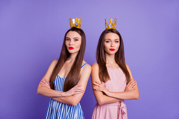 Photo of confident pretty two girlfriends wear dresses hair accessories arms folded isolated violet color background