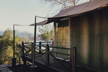 Cabin in the woods on a sunny spring day. Modern bnb tent with full length windows and panoramic view. Copy space, background.