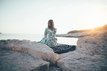 Lonely young woman sitting on beach