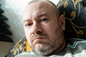 Ordinary middle aged man. The unshaven face of a man in his forties. Unhealthy appearance of the face, fatigue.