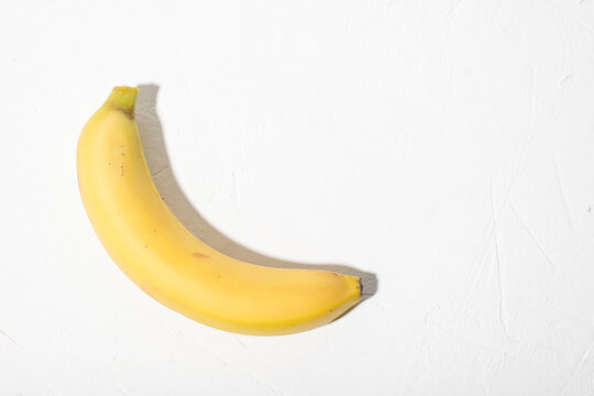 Banana on a white background. Whole unpeeled natural banana.