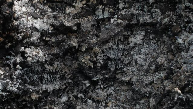 Ashes smouldering after a fire. The remnants of wood slowly decay in the smoke and embers