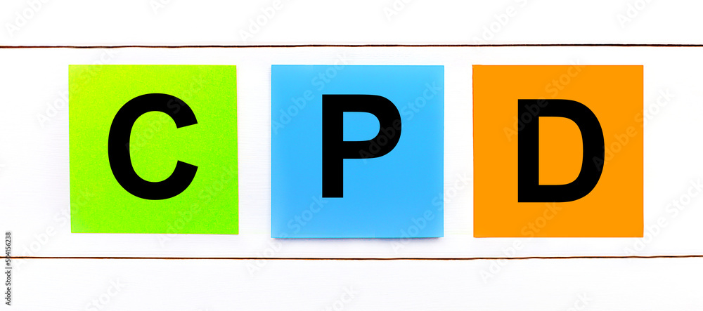 Aufkleber on a white wooden background there are three colorful bright stickers with text cpd continuing profe