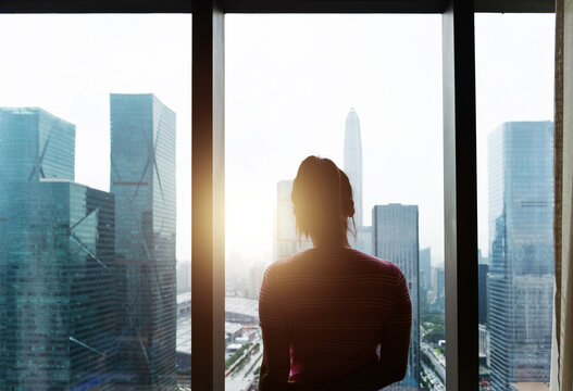 Woman standing in front of the window - Powered by Adobe
