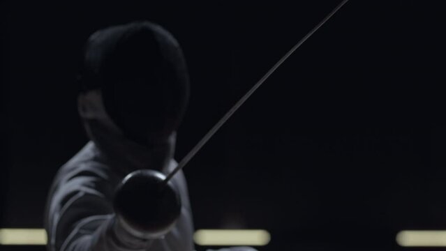Professional male fencer takes a starting pose before the fight
