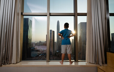 Little boy standing in front of window