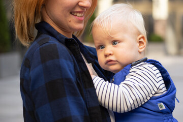 Woman portrait with child baby boy outdoors on urban background