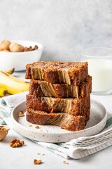 Pieces of american homemade sliced banana bread with chopped walnuts, chocolate and cinnamon. Stack of pieces of bread. Breakfast concept. Selective focus.