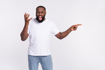 Photo of sad aggressive guy dressed casual t-shirt shouting pointing empty space isolated white...
