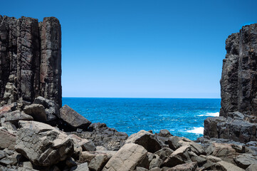 from Kiama Australia see through stone gate with blue sky and ocean
