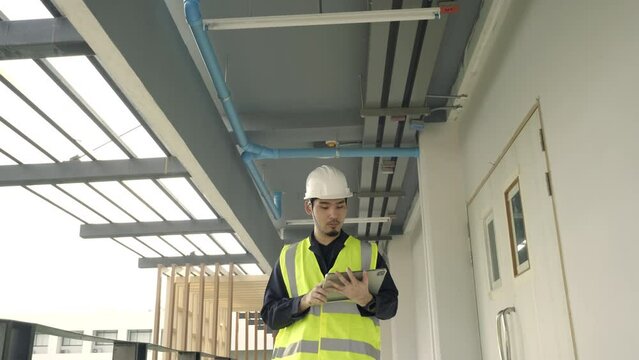 Portrait Asian man Civil Engineer working inspection at construction site. Architect working use BIM technology and digital construction application on digital tablet.