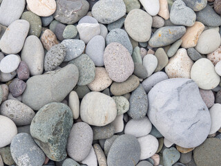 Big stones on the beach. Background from stones. Boulders on the seashore. Smooth cobblestones.