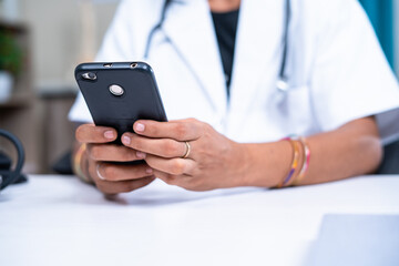 Close up women doctor hands using mobile phone at hospital - concept of relaxing, healthcare and social media