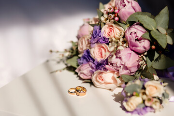 Wedding bouquet and rings on a light background. Wedding concept.