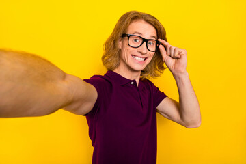 Portrait of cheerful person hand touch eyewear make selfie record video isolated on yellow color background