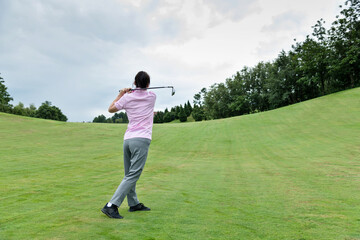 Woman golf player swinging golf club