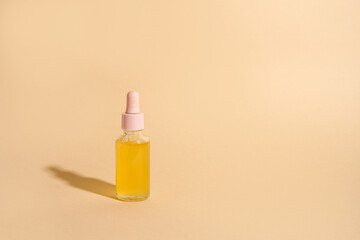 Cosmetic oil bottle with shadow on light background. Horizontal mockup, banner, poster, copy space. Yellow serum, extract, emulsion, eco lotion